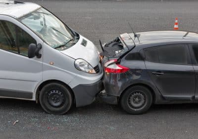 Rear-end car accident on a city street in Atlanta, Georgia, showing vehicle damage and injury risk.