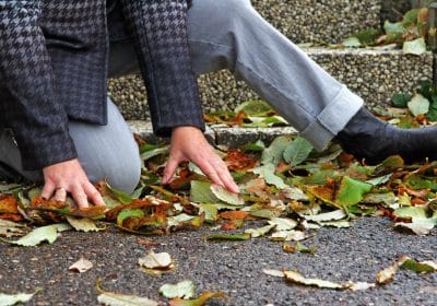 Injured man lying on the ground after slipping on a sidewalk in front of a house