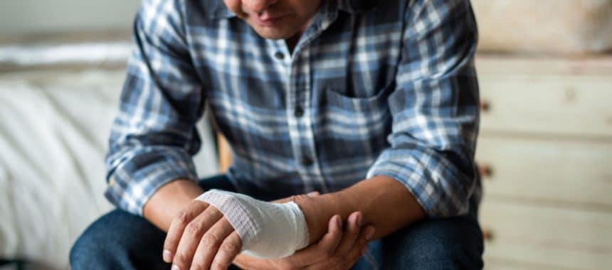 Man looking at bandaged hand after dog bite injury in Georgia