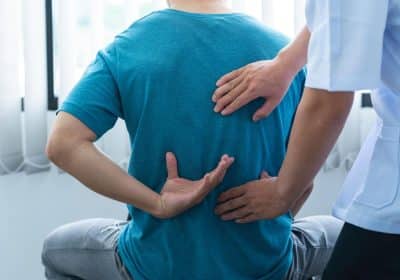 Doctor evaluating serious back and neck injury patient in Georgia